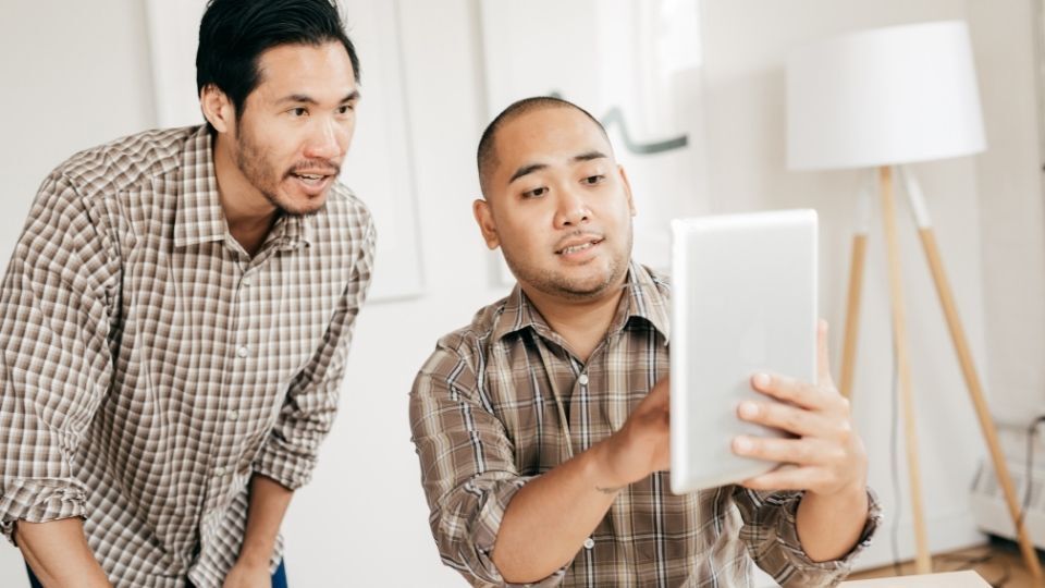 How to Get Inspired Interior Design with Signage 4 (An Image can be seen showing two designer looking at interior designs for inspiration) How to Get Inspired Interior Design with Signage