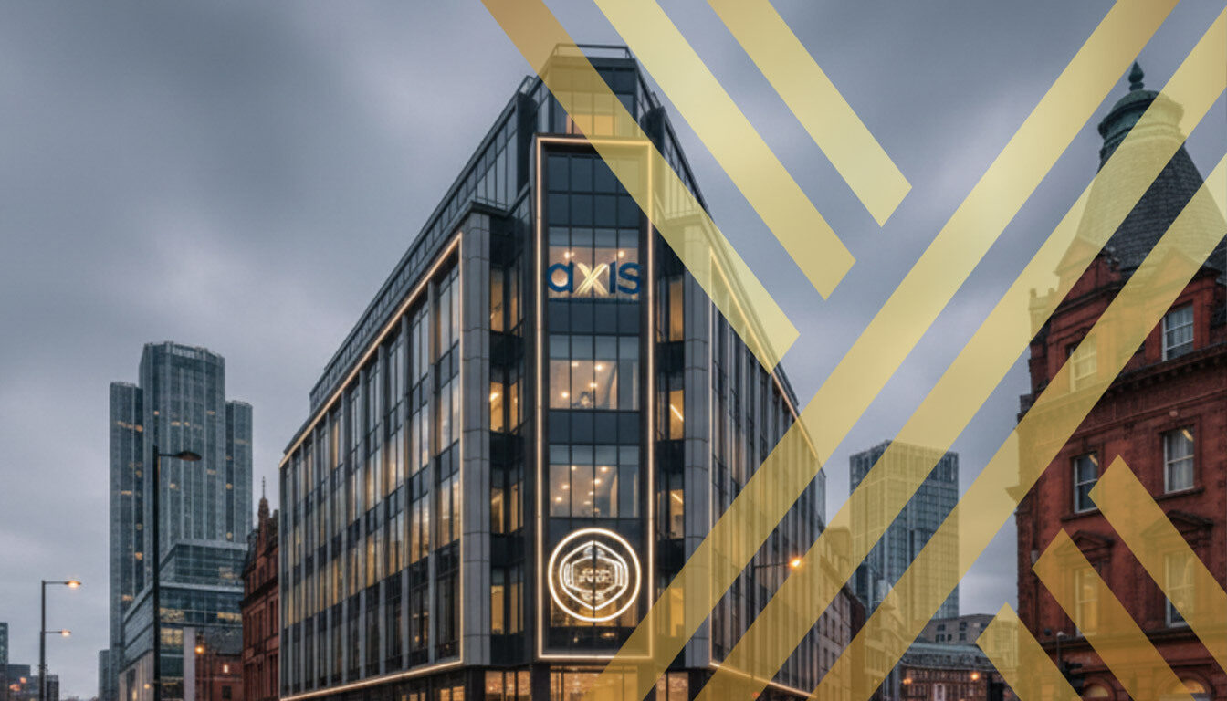 A sleek, modern corporate building at a busy intersection in Manchester at dusk, featuring the "AXIS Solicitors" logo prominently displayed on its facade and a glowing sign on the street level.