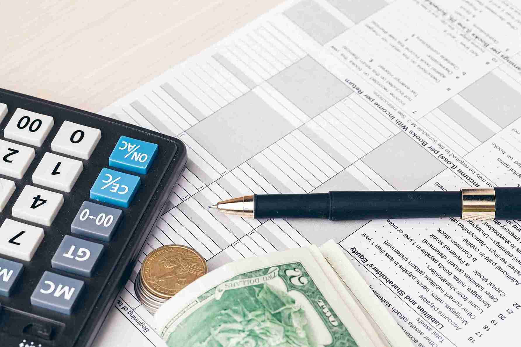 The close up of accounting documents with money.