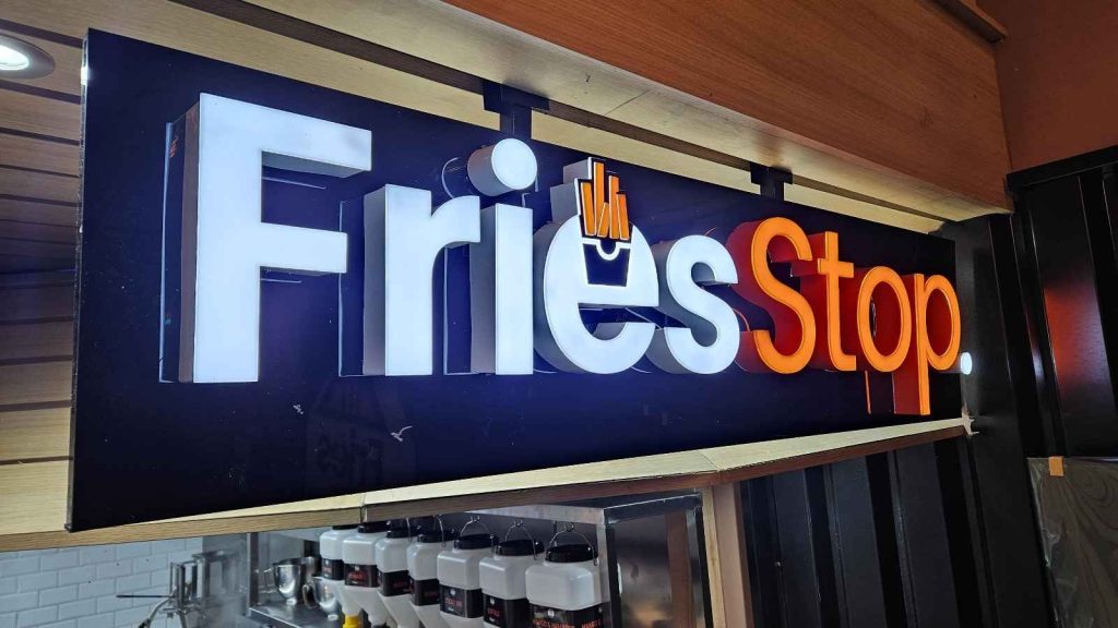Indoor signs featuring illuminated 3D Fries Stop branding installed inside a restaurant