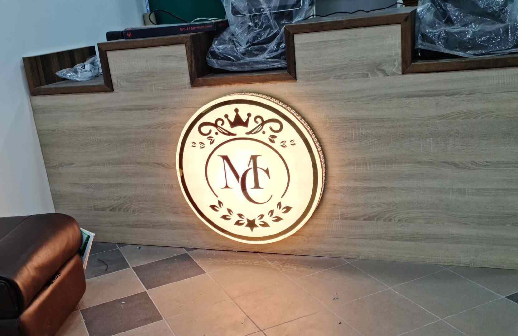 Reception sign featuring a custom illuminated 3D LED logo installed behind a front desk