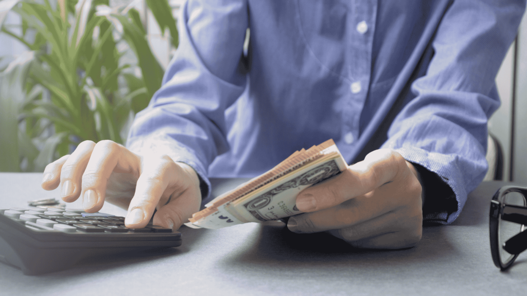 This image represents a person calculating his due tax and preparing to pay it to avoid Tax Evasion Penalties