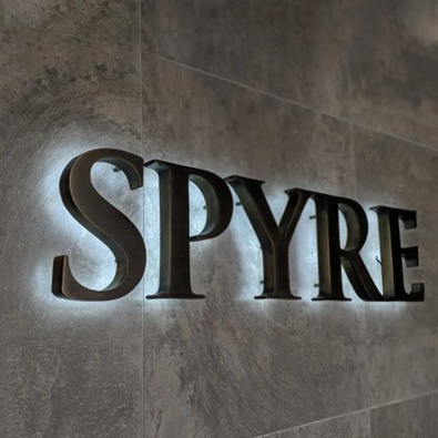 Reception sign with sleek black 3D letters mounted on stone-effect wall and soft backlighting