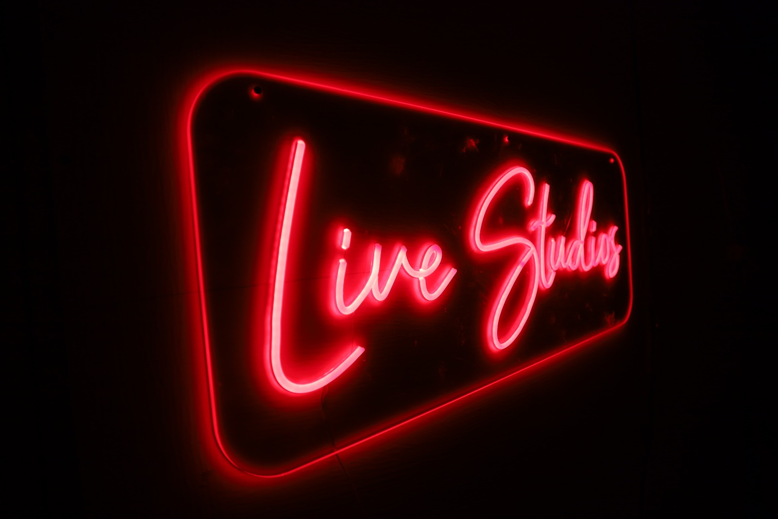 Neon signs featuring Live Studios text in red LED lighting for creative spaces