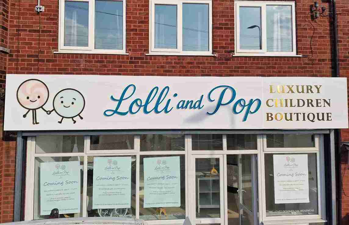 Colorful storefront of Lolli and Pop children's boutique, showcasing playful clothing and accessories for kids.