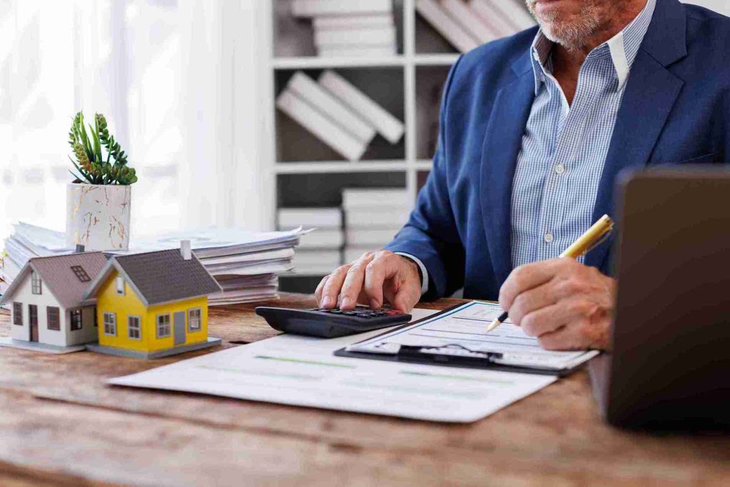 A person keeping a record of all the rental income while ensuring the amount by calculating it.