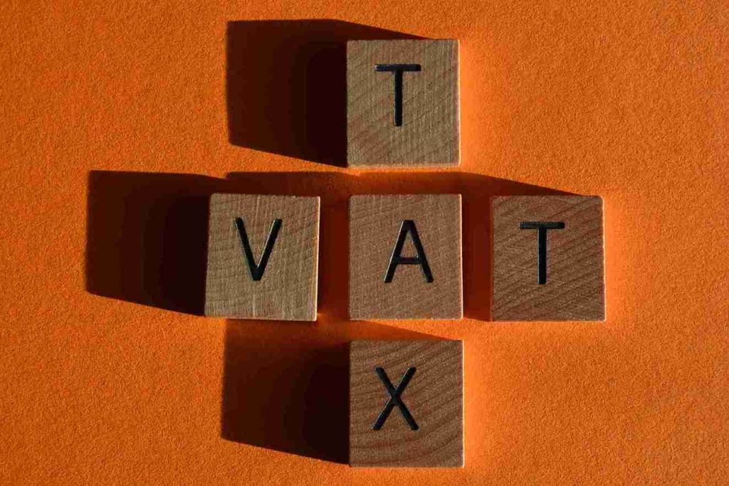 In the image a calculator can be seen showcasing VAT and percentages in the back
