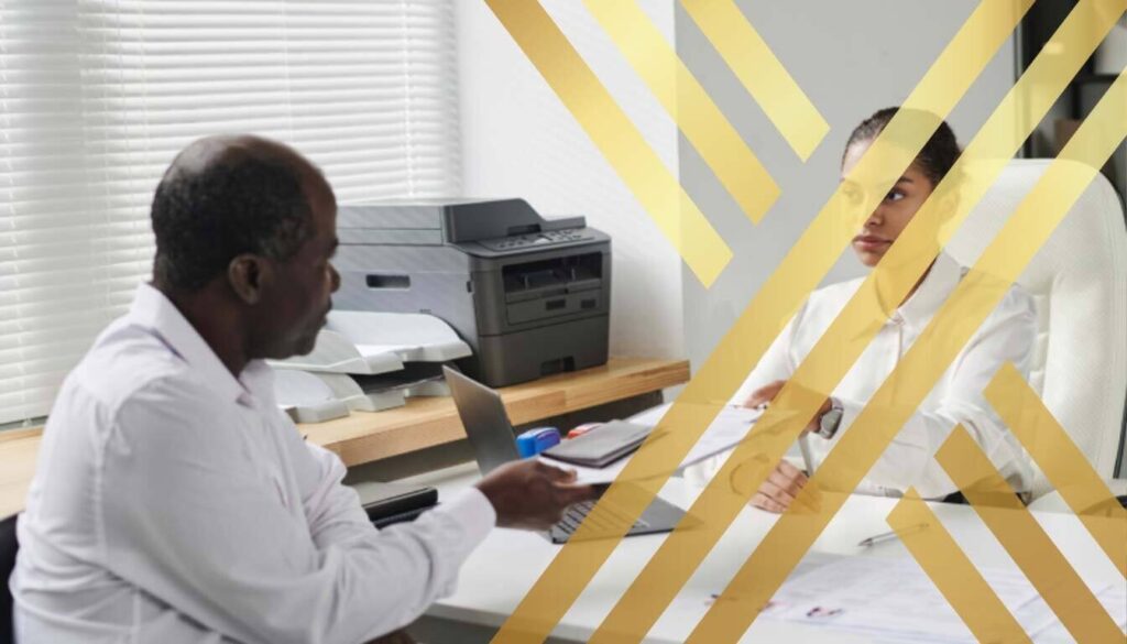 An immigration applicant handing documents across a desk to a reviewing officer for an eligibility assessment for Global Talent ILR.