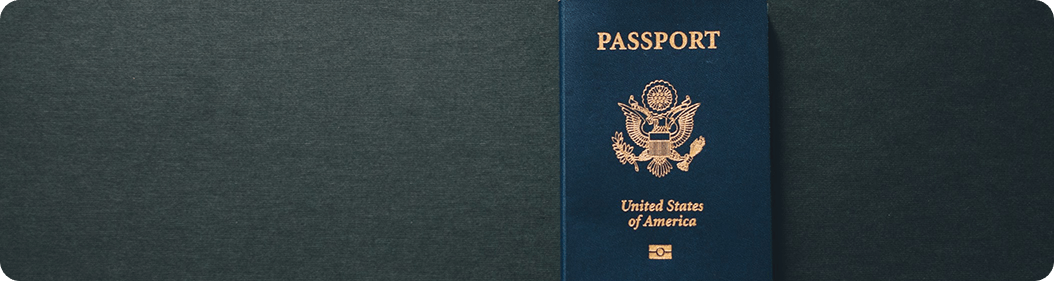 A passport book displayed on a black background, emphasizing its cover and details.