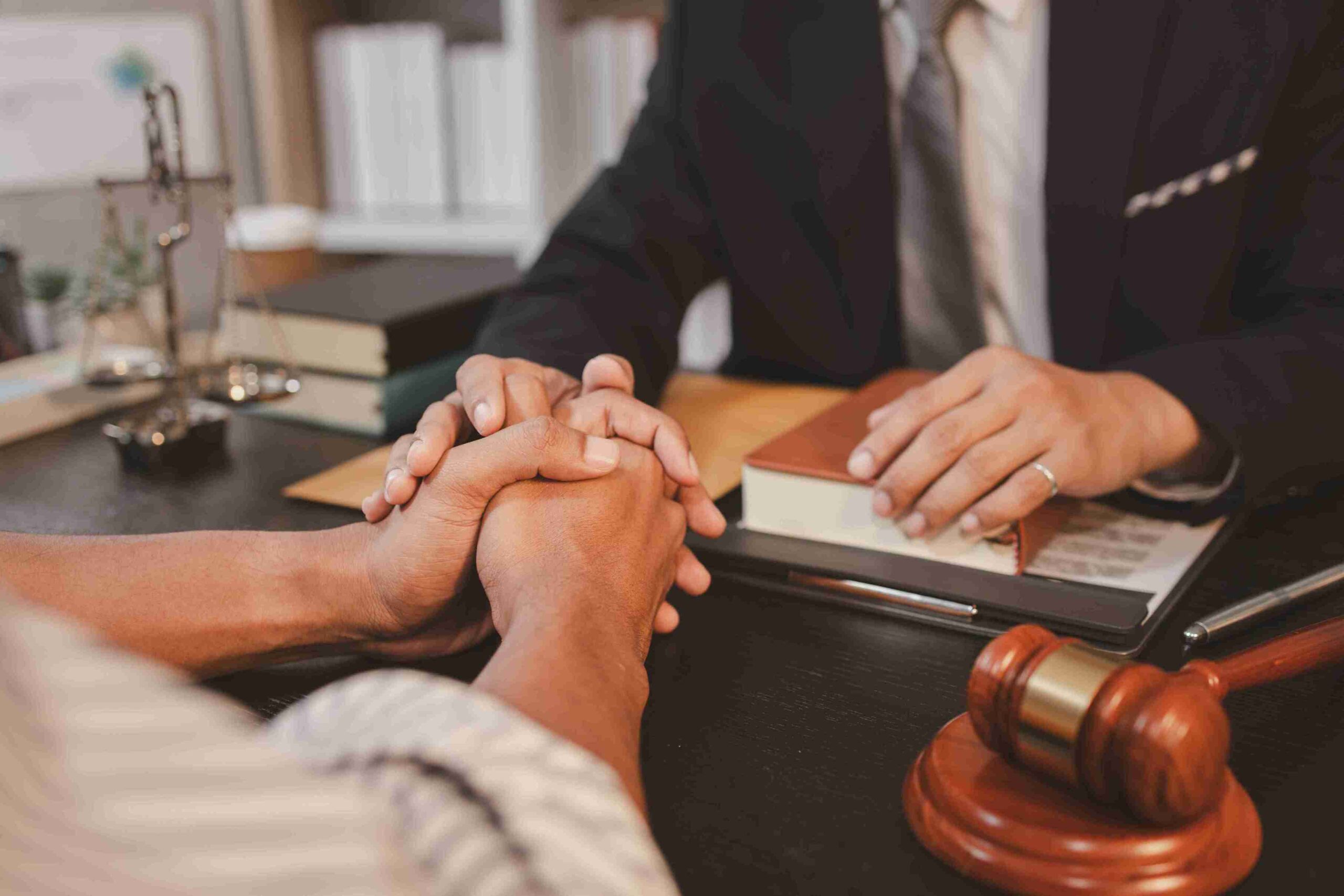 A lawyer and client clasp hands, symbolizing support and collaboration in tenant legal matters.