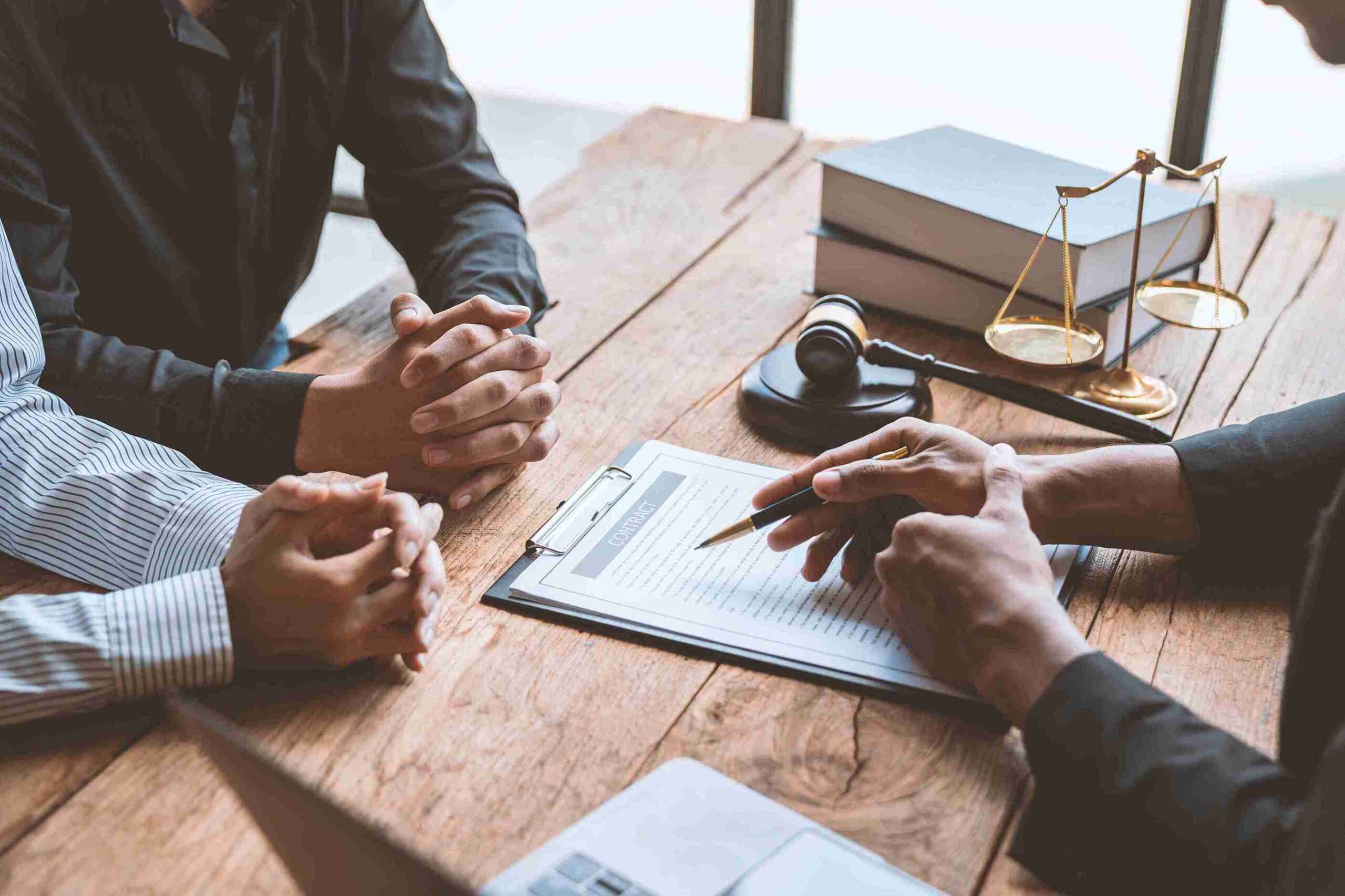 A lawyer and two business people discussing divorce at a table, focused and engaged in conversation.