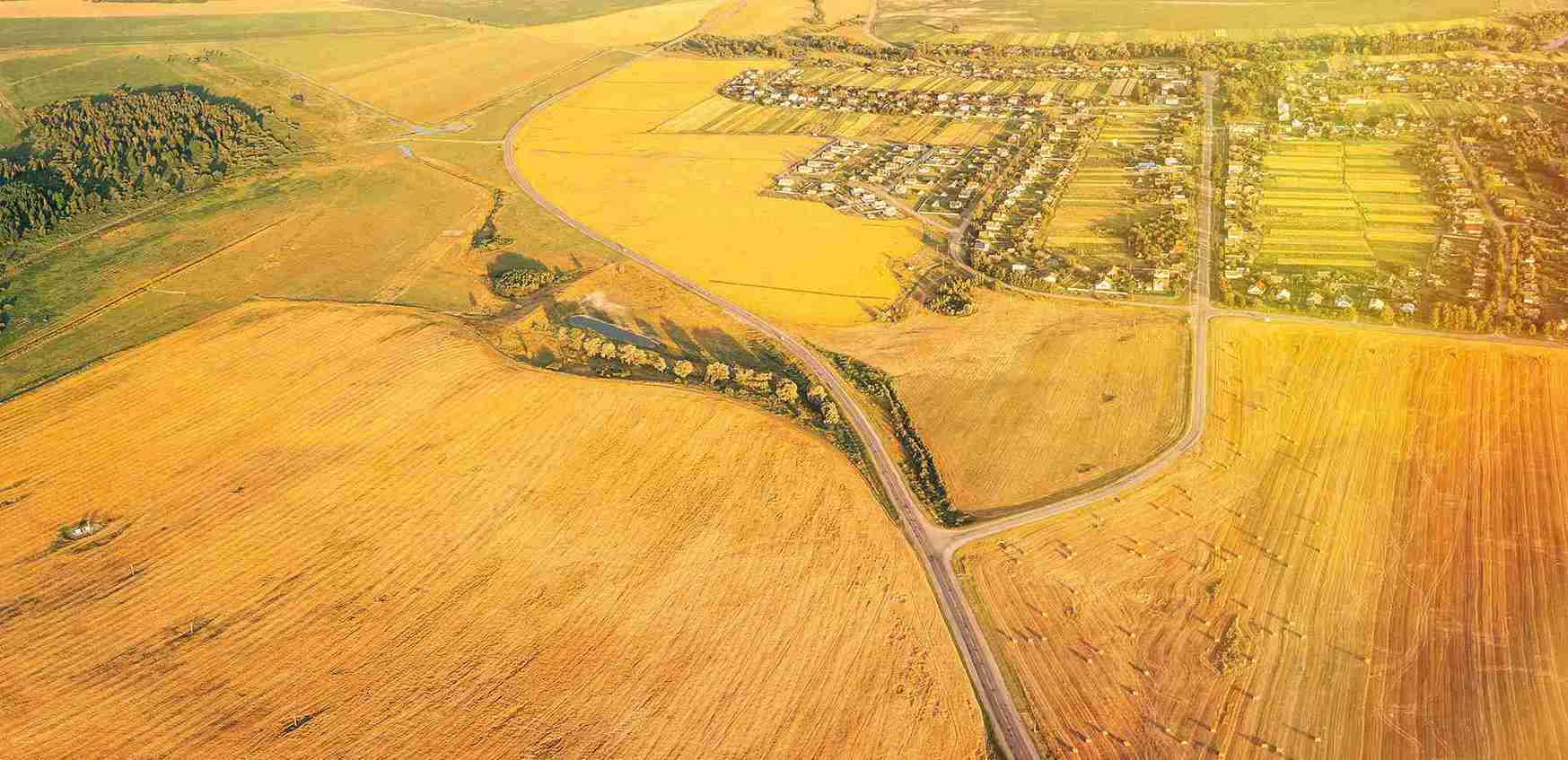 Aerial view of a rural area featuring a winding road, highlighting boundary and ownership disputes in the landscape.