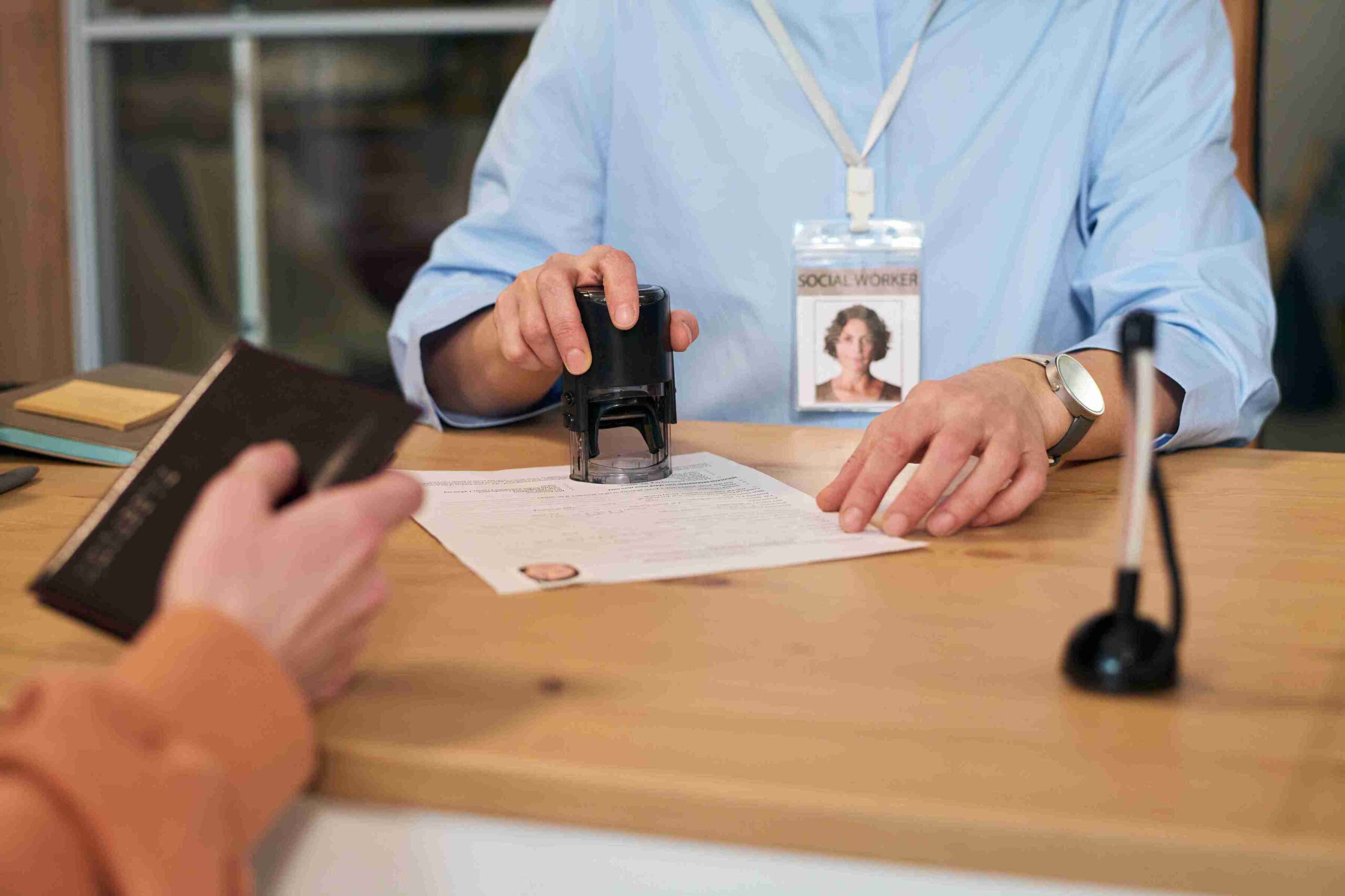 A man stamps his signature on a document, indicating approval or authorization.