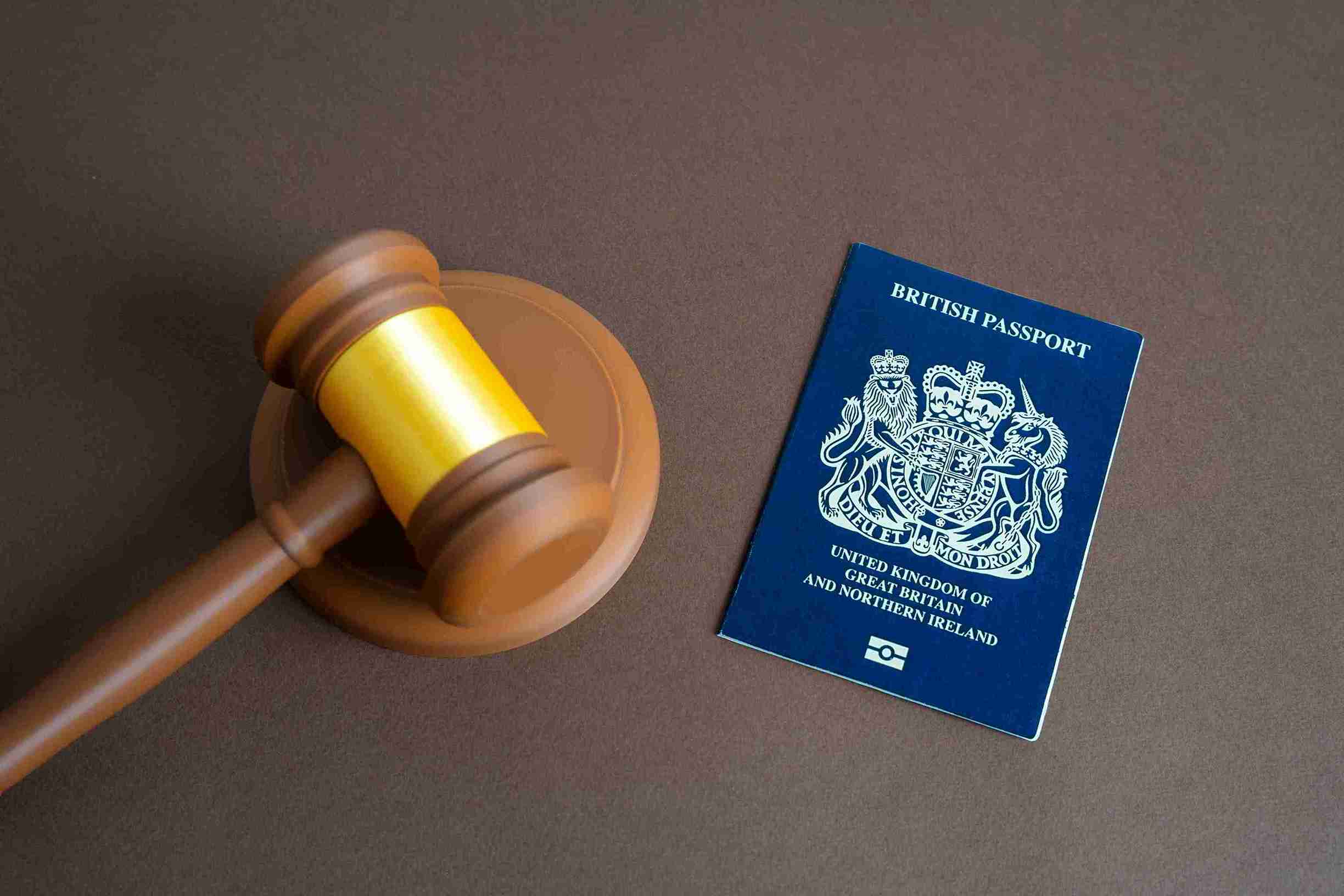British passport next to a gavel, symbolizing legal authority and citizenship.