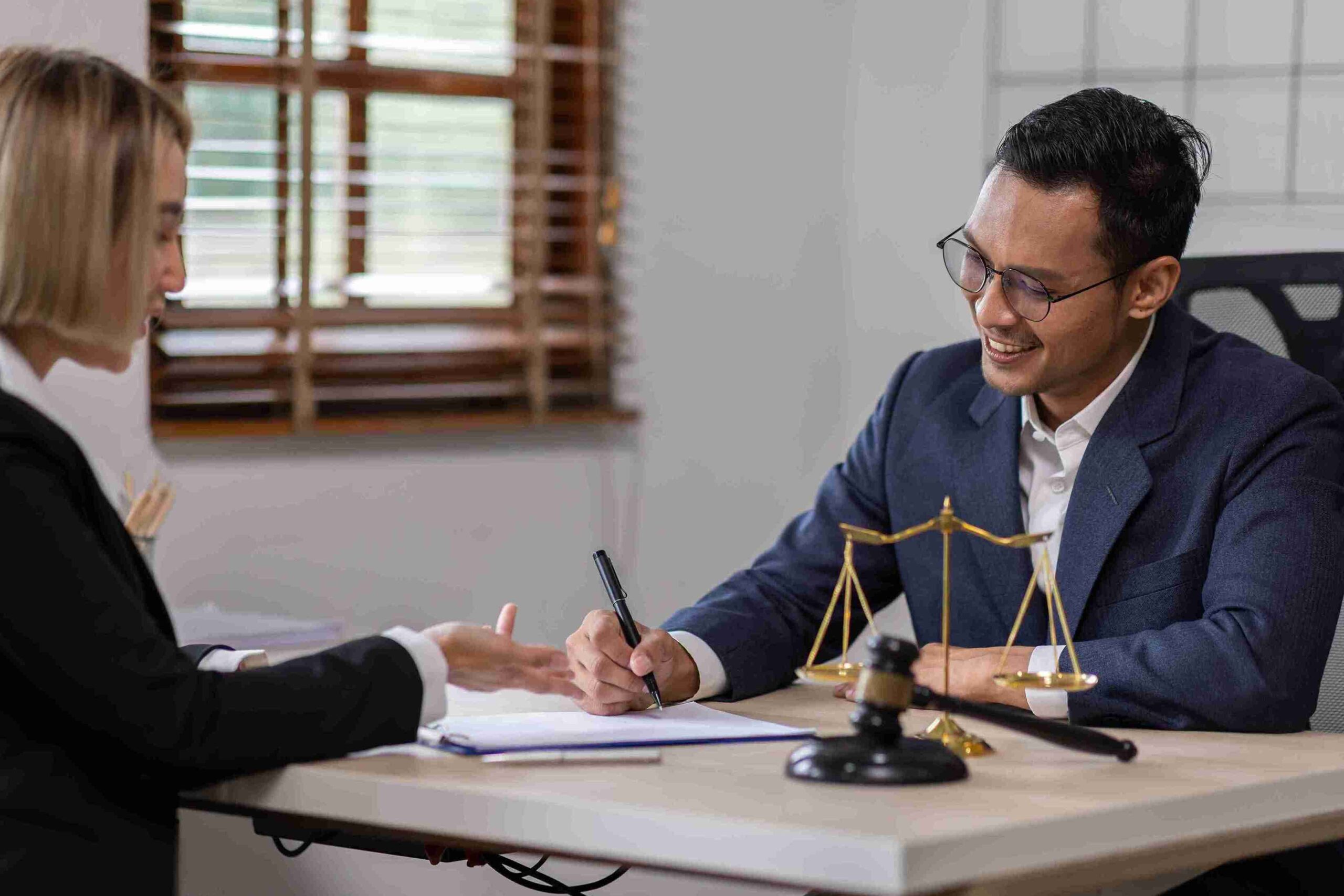 Man and woman in signing a document with gavel and scales, representing a Lasting Power of Attorney protecting personal and financial decisions.