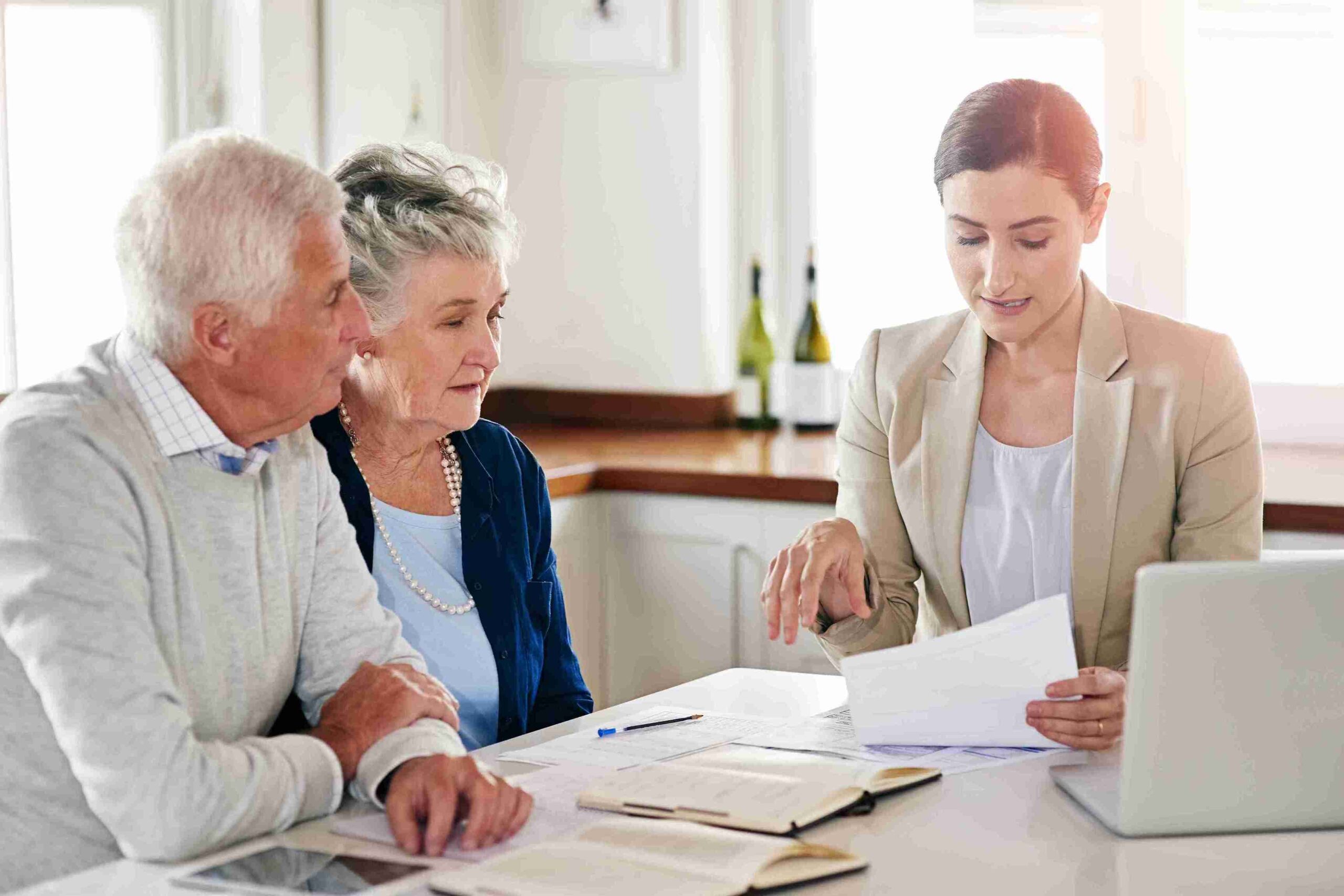 Mature couple consulting professional woman at table with documents, representing specialist planning for complex estates.