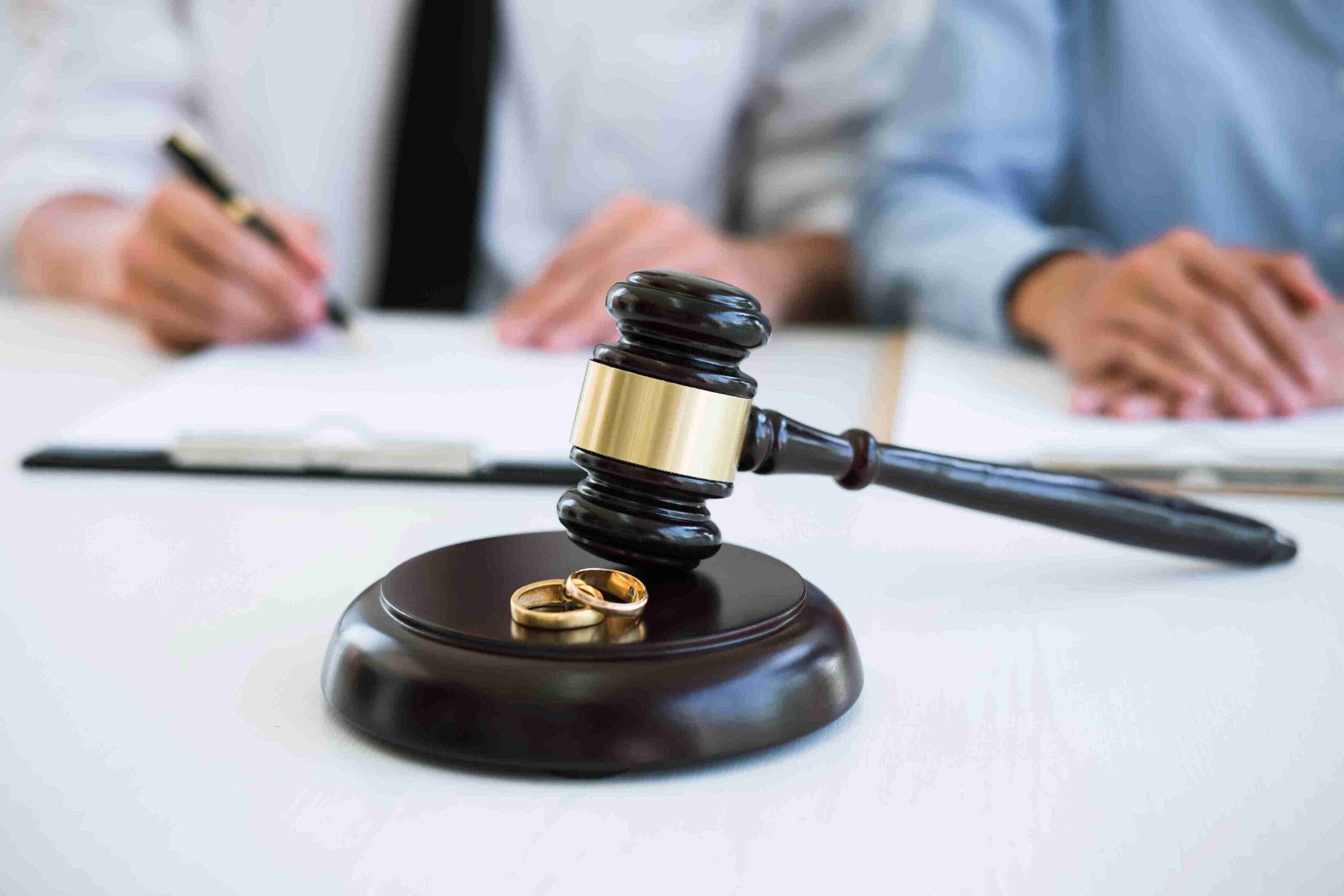 Wedding rings resting on a judge's gavel, symbolizing the union of marriage and legal agreements.