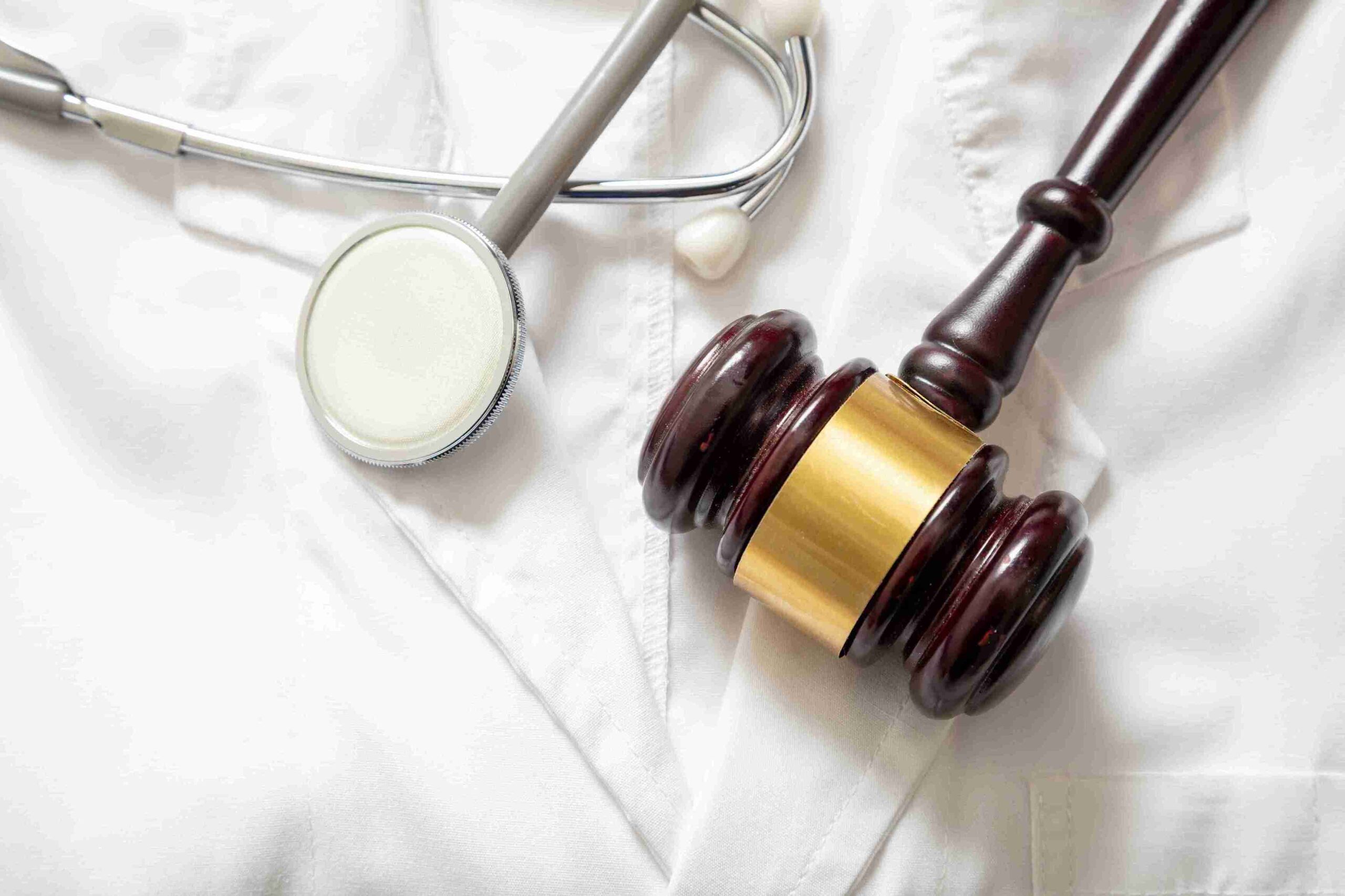 A gavel and stethoscope on a white background, symbolizing legal support for medical injury compensation.