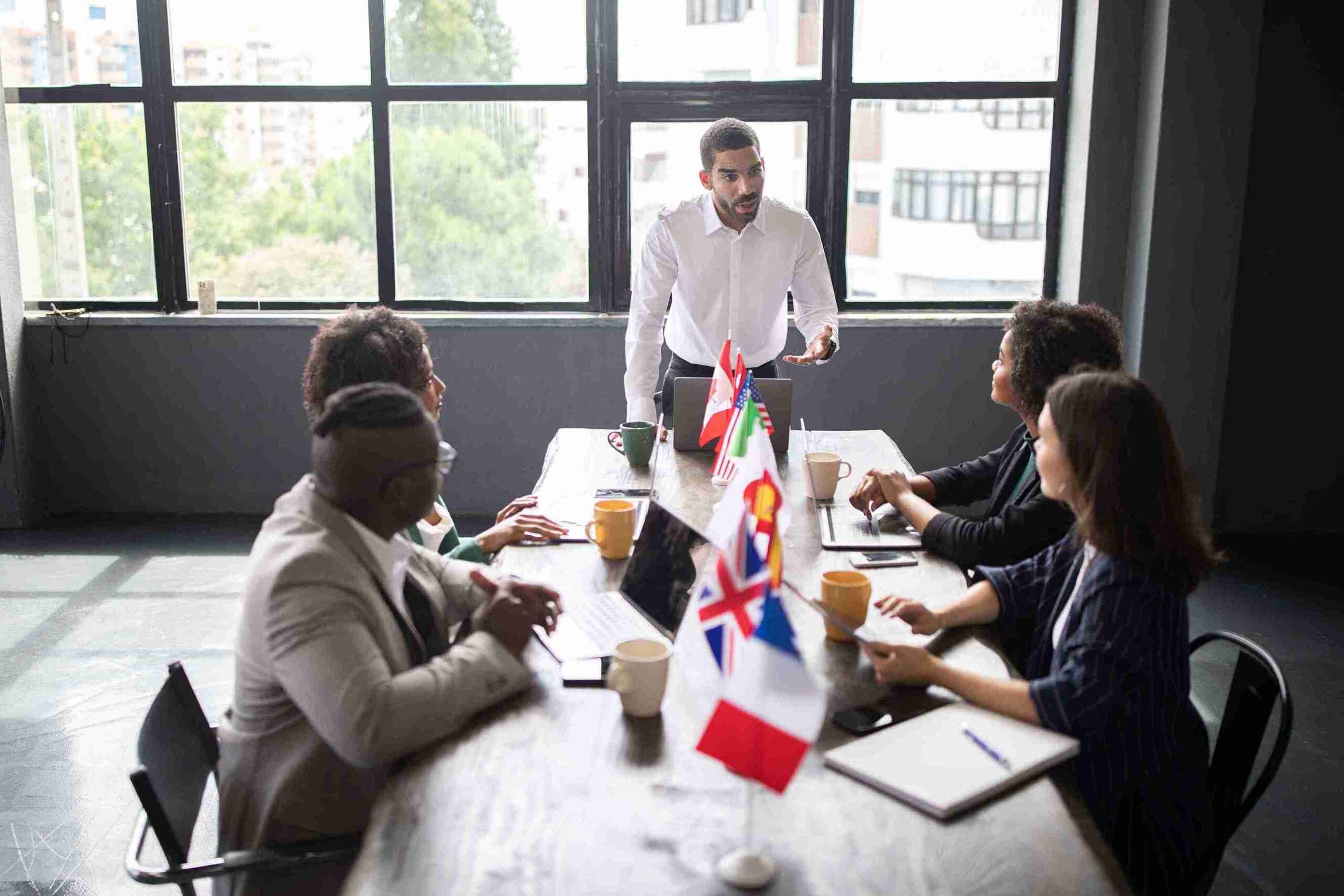 A man presents to colleagues in a UK business setting, discussing topics and strategies