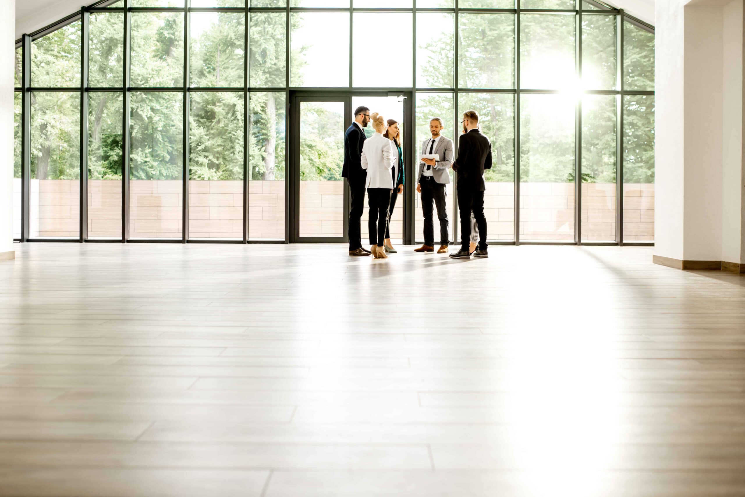 Three business people discussing lease arrangements in an empty room, emphasizing expert legal assistance for leases.