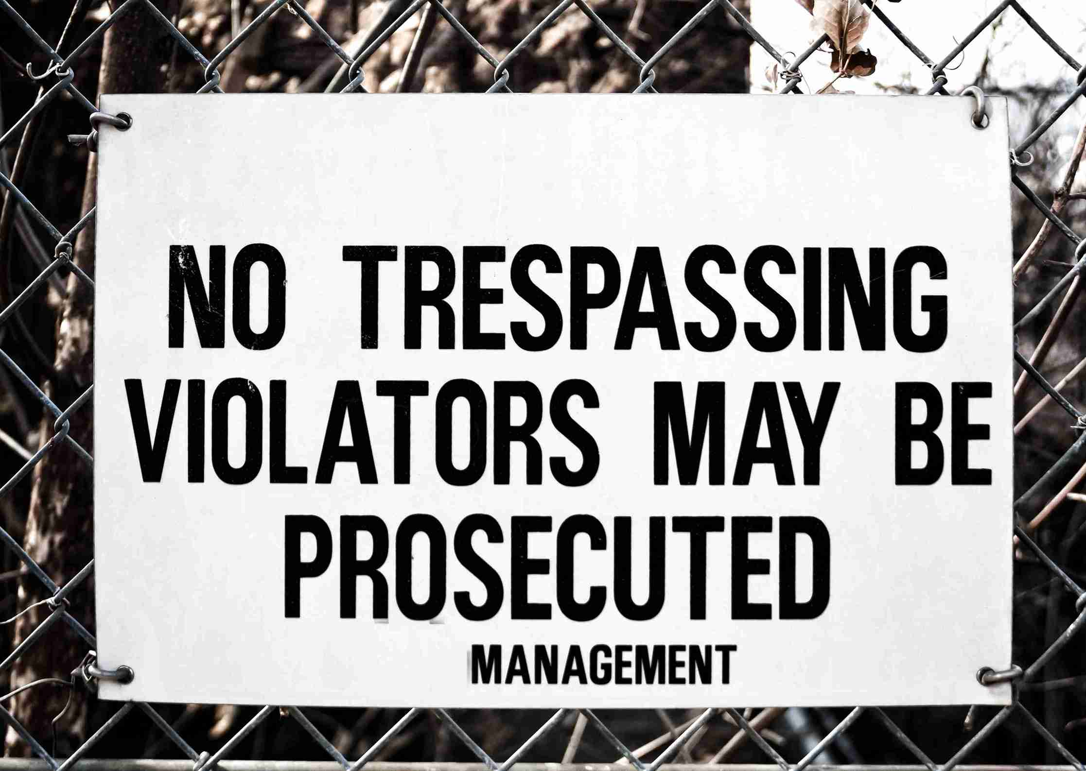 No trespassing sign stating violators may be prosecuted, emphasizing legal consequences for unauthorized entry.