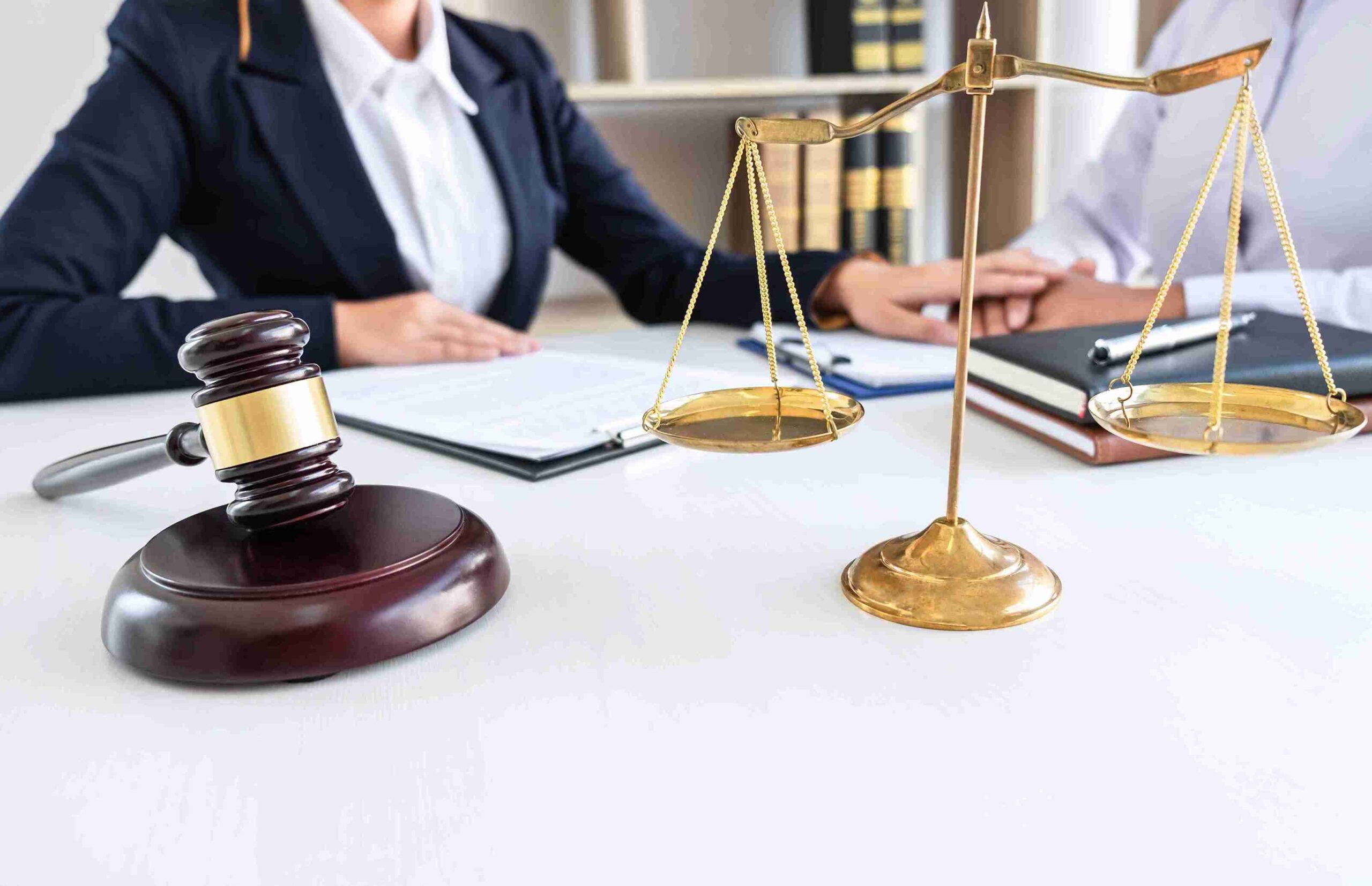 Gavel and scales with professionals reviewing legal documents, representing the right to professional advice, accurate HMRC data protection compliance.