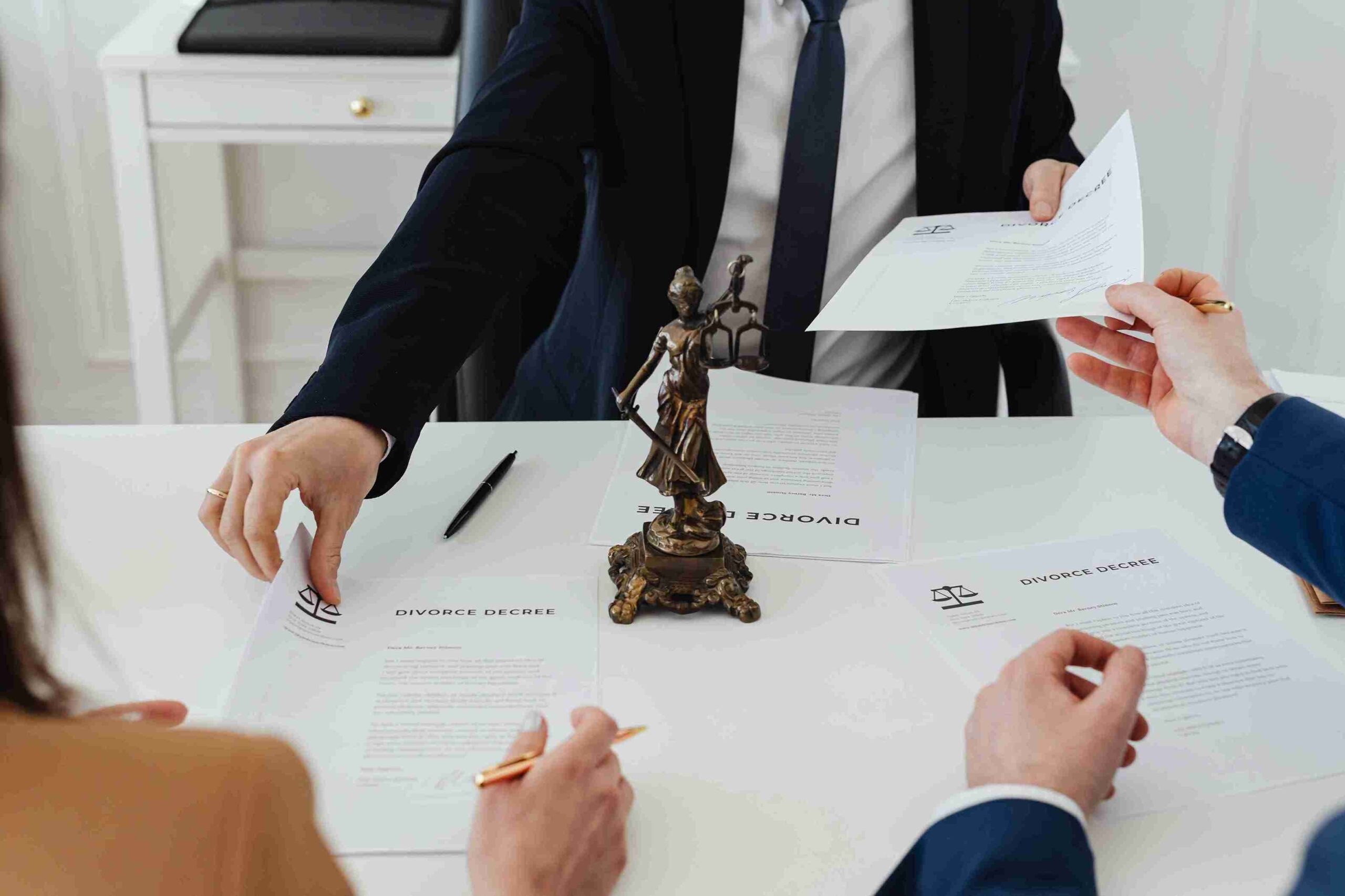 A lawyer and two business professionals engaged in discussion at a conference table.