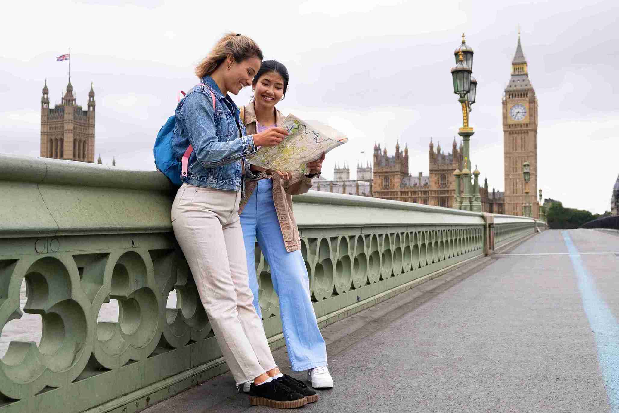 Two women studying a map together on a bridge, likely planning their visit while exploring the area.