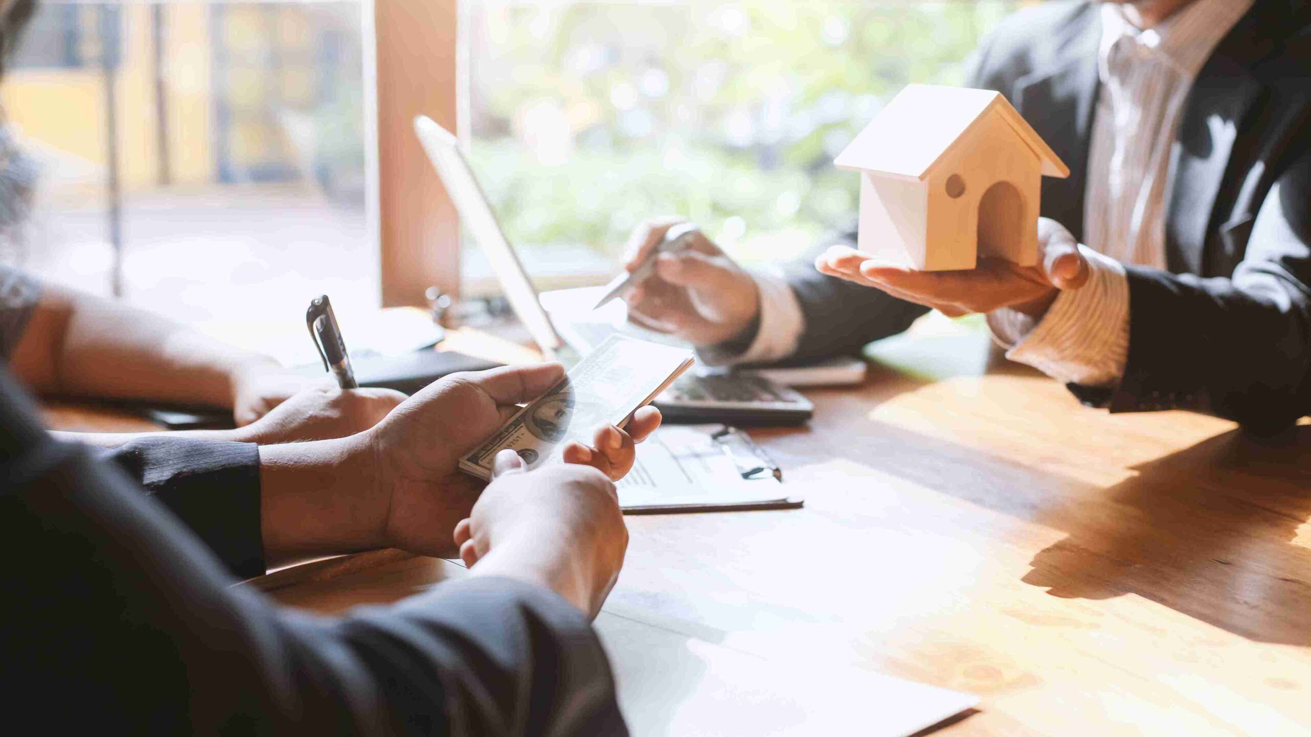 A man and woman discuss a house model at a table, highlighting key aspects of property matters