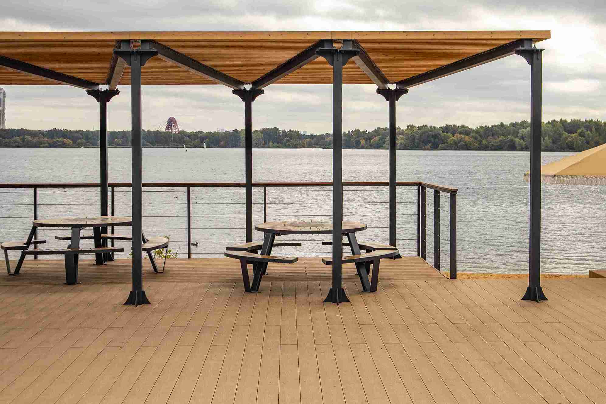 waterfront terrace with round table under pergol