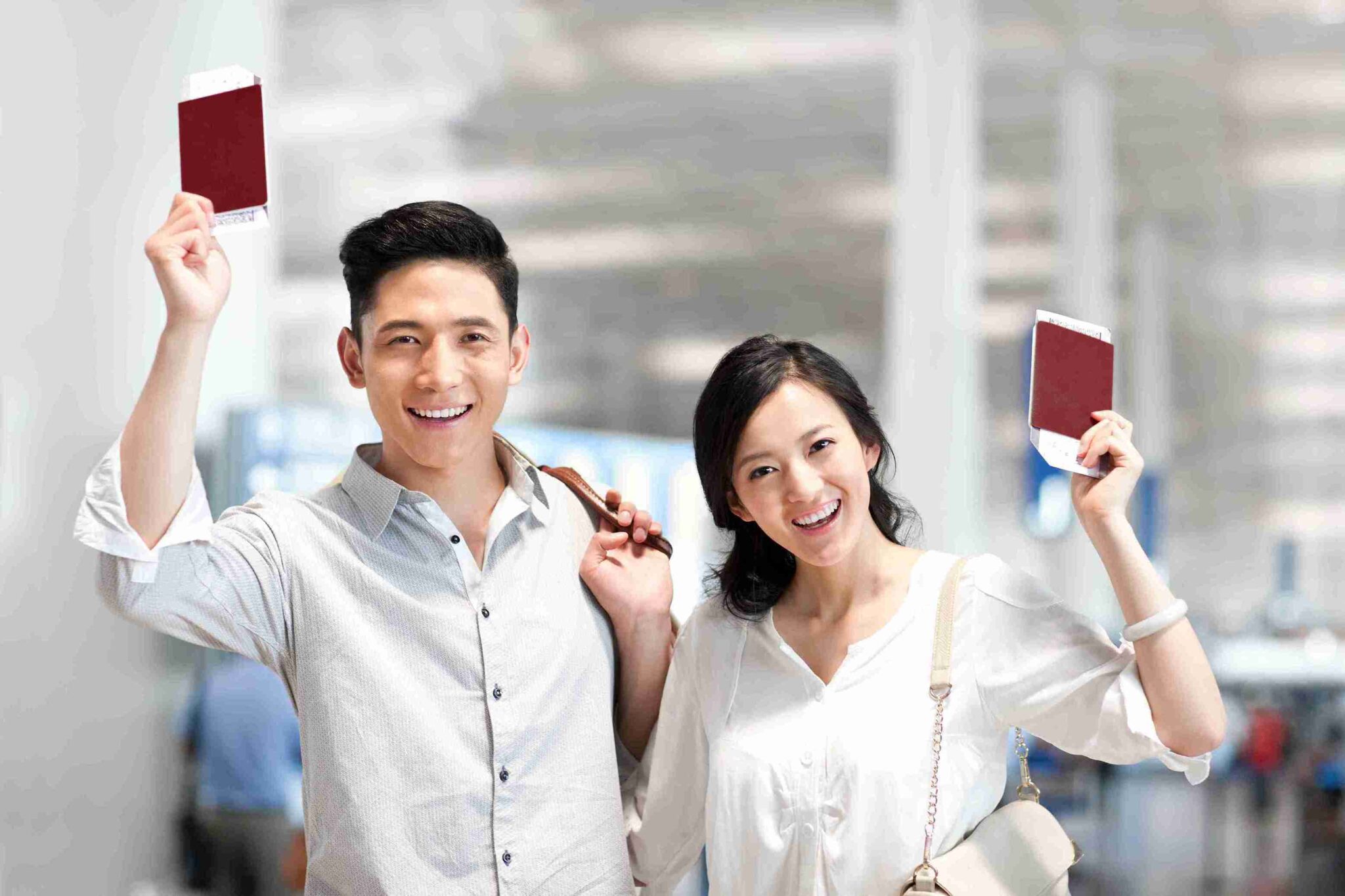 A man and woman proudly display their passports, smiling and ready for their travel adventure.