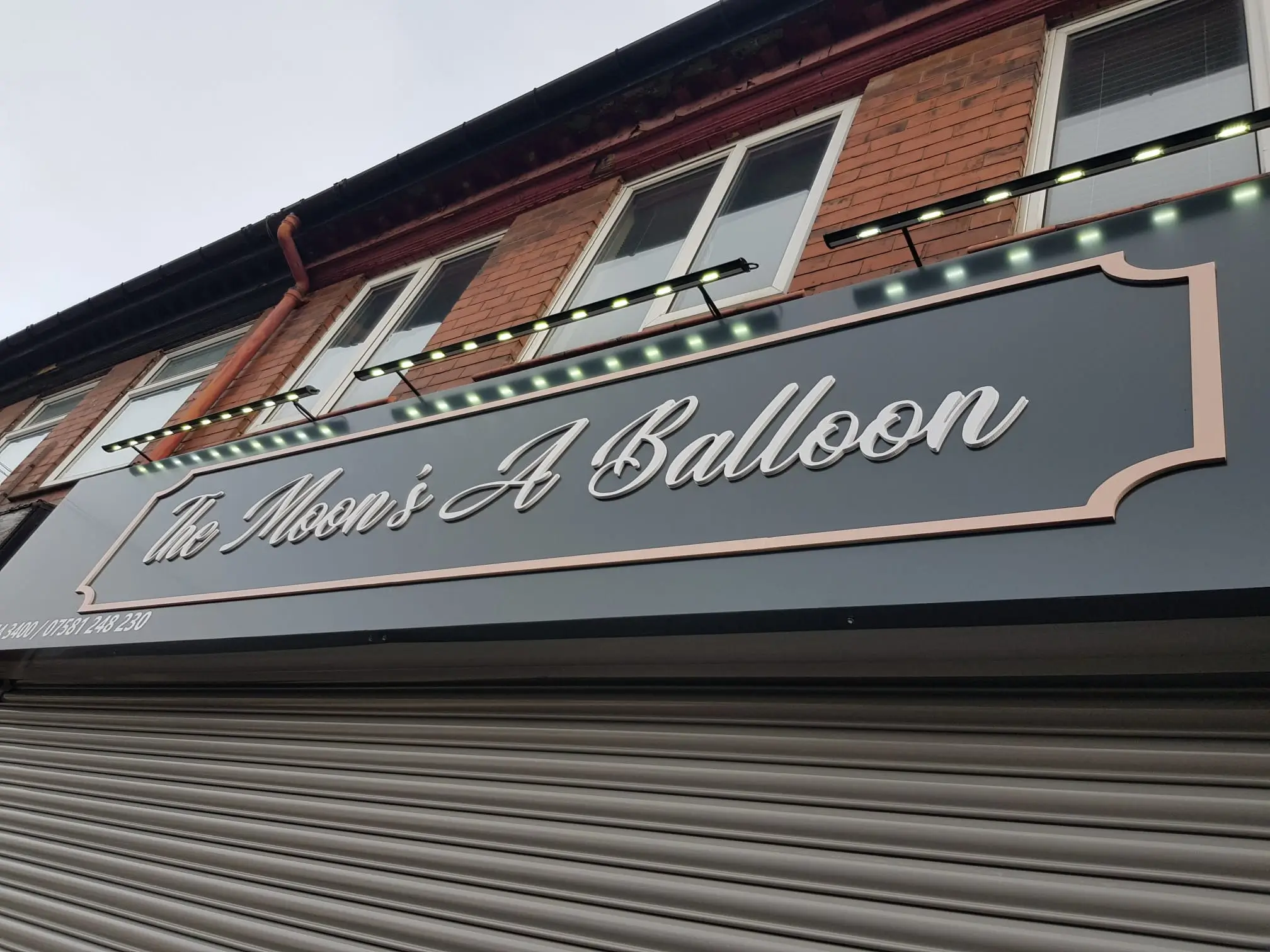 A sign on a building reads "The Man's Balloon," featuring colorful balloon graphics.