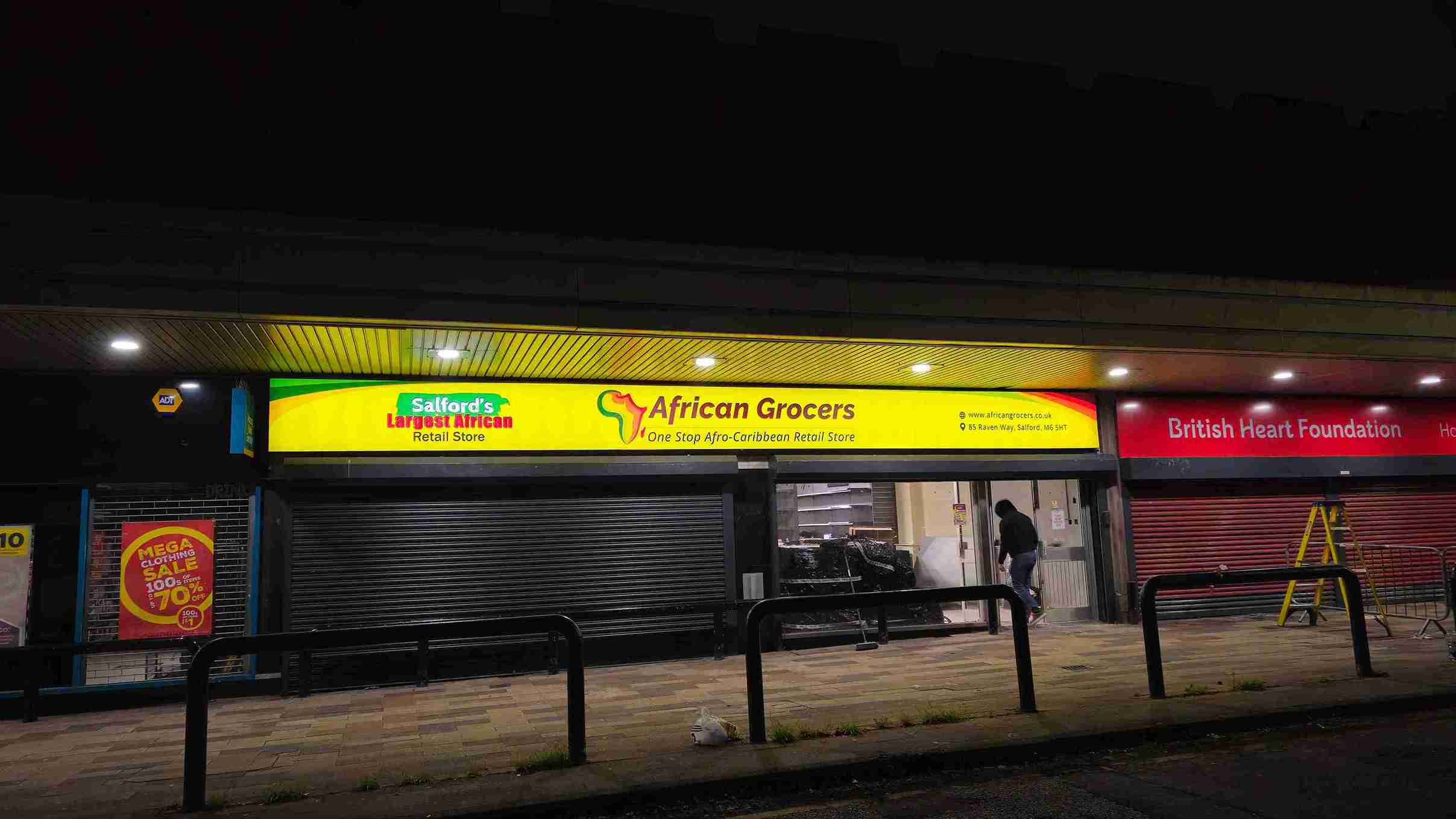 A brightly lit store front at night featuring a prominent yellow sign, creating a warm and inviting atmosphere.