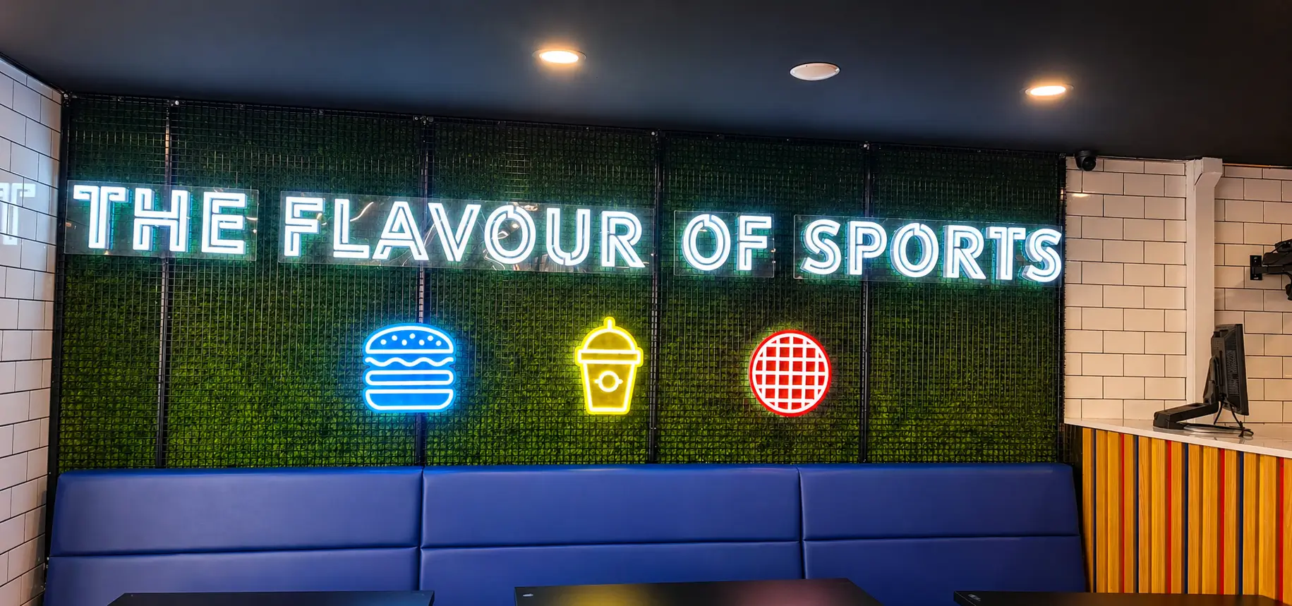 A vibrant sports restaurant filled with fans enjoying food and drinks while watching games on large screens.