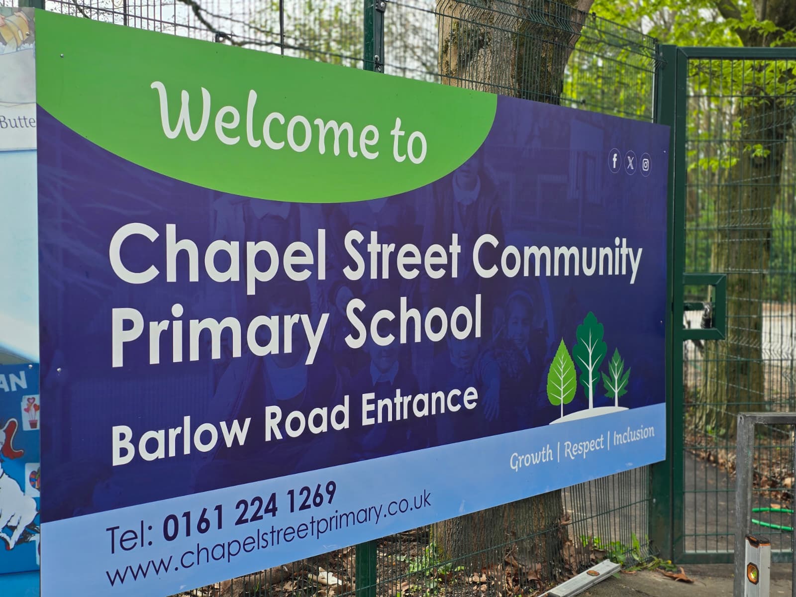 A large banner promoting a school, displayed prominently in a park setting, attracting visitors and families.