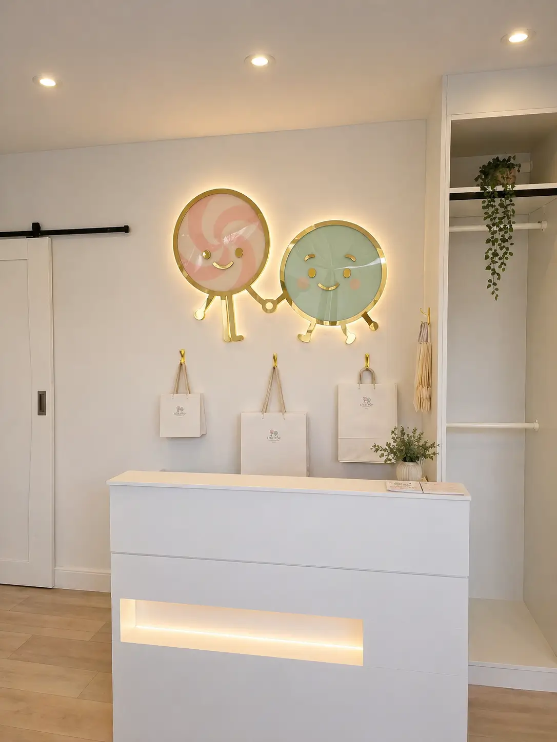 A bright reception area featuring a white counter with two colorful donuts displayed on it.